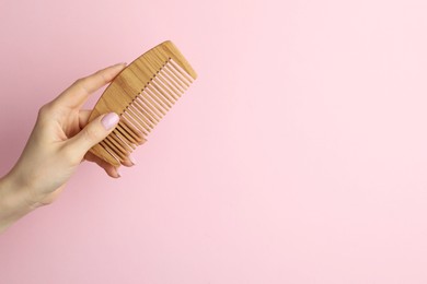 Photo of Woman with wooden comb on pink background, closeup. Space for text