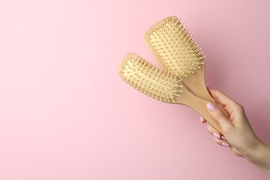 Photo of Woman with wooden brushes on pink background, closeup. Space for text