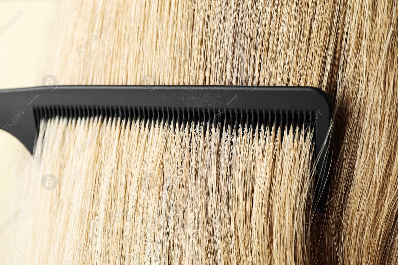 Photo of Brushing hair with plastic comb, closeup view