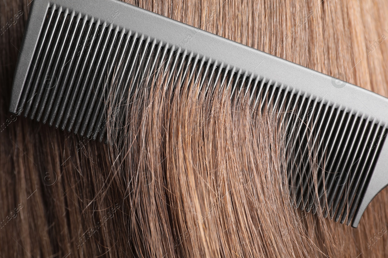 Photo of Brushing hair with plastic comb, closeup view