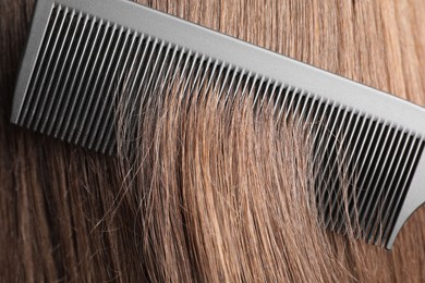 Photo of Brushing hair with plastic comb, closeup view