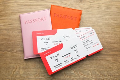 Photo of Travel agency. Flight tickets and passports on wooden table, flat lay