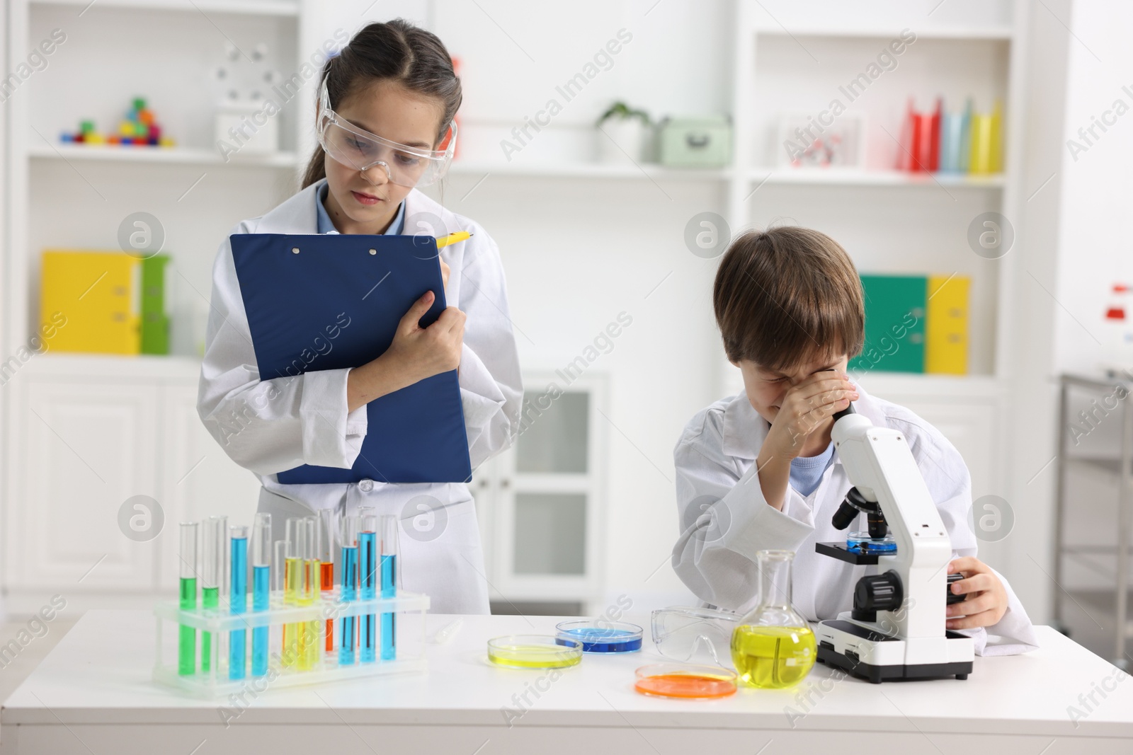 Photo of Children doing chemical experiment at desk indoors