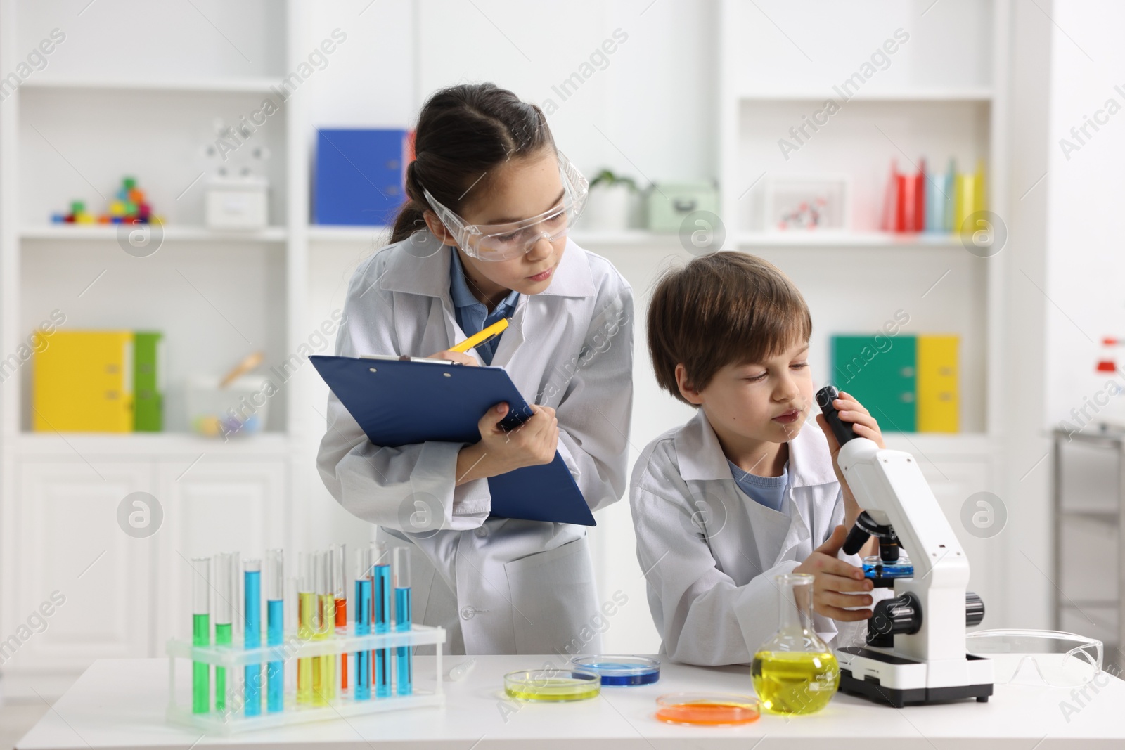 Photo of Children doing chemical experiment at desk indoors