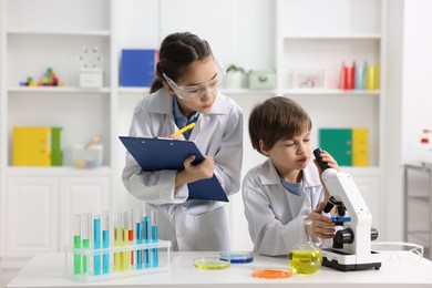 Photo of Children doing chemical experiment at desk indoors