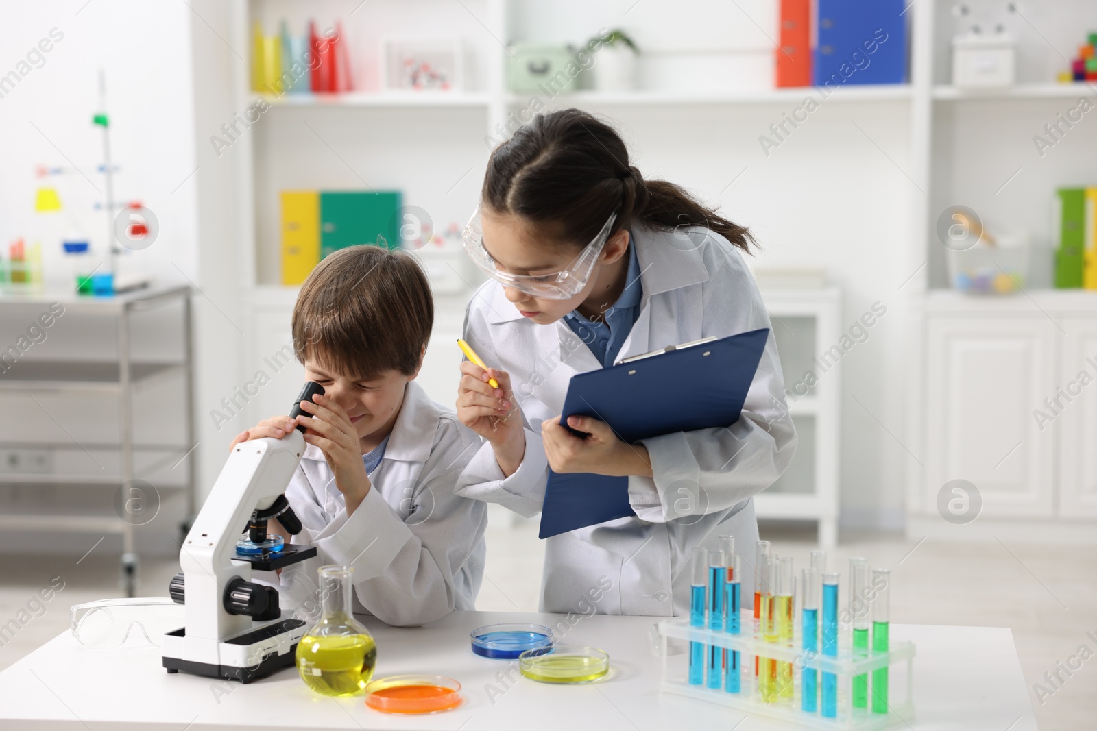 Photo of Children doing chemical experiment at desk indoors