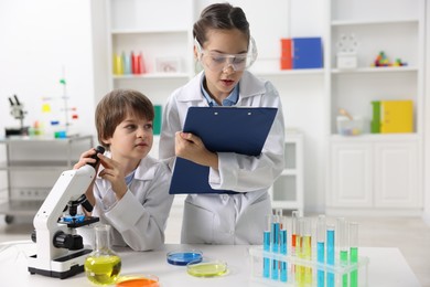 Photo of Children doing chemical experiment at desk indoors