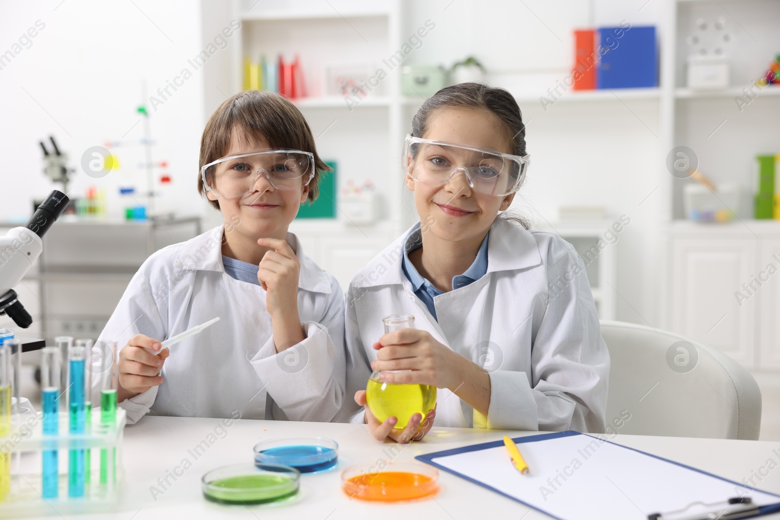 Photo of Children doing chemical experiment at desk indoors