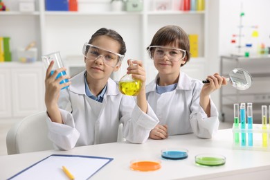 Photo of Children doing chemical experiment at desk indoors