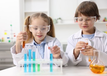 Photo of Children doing chemical experiment at desk indoors