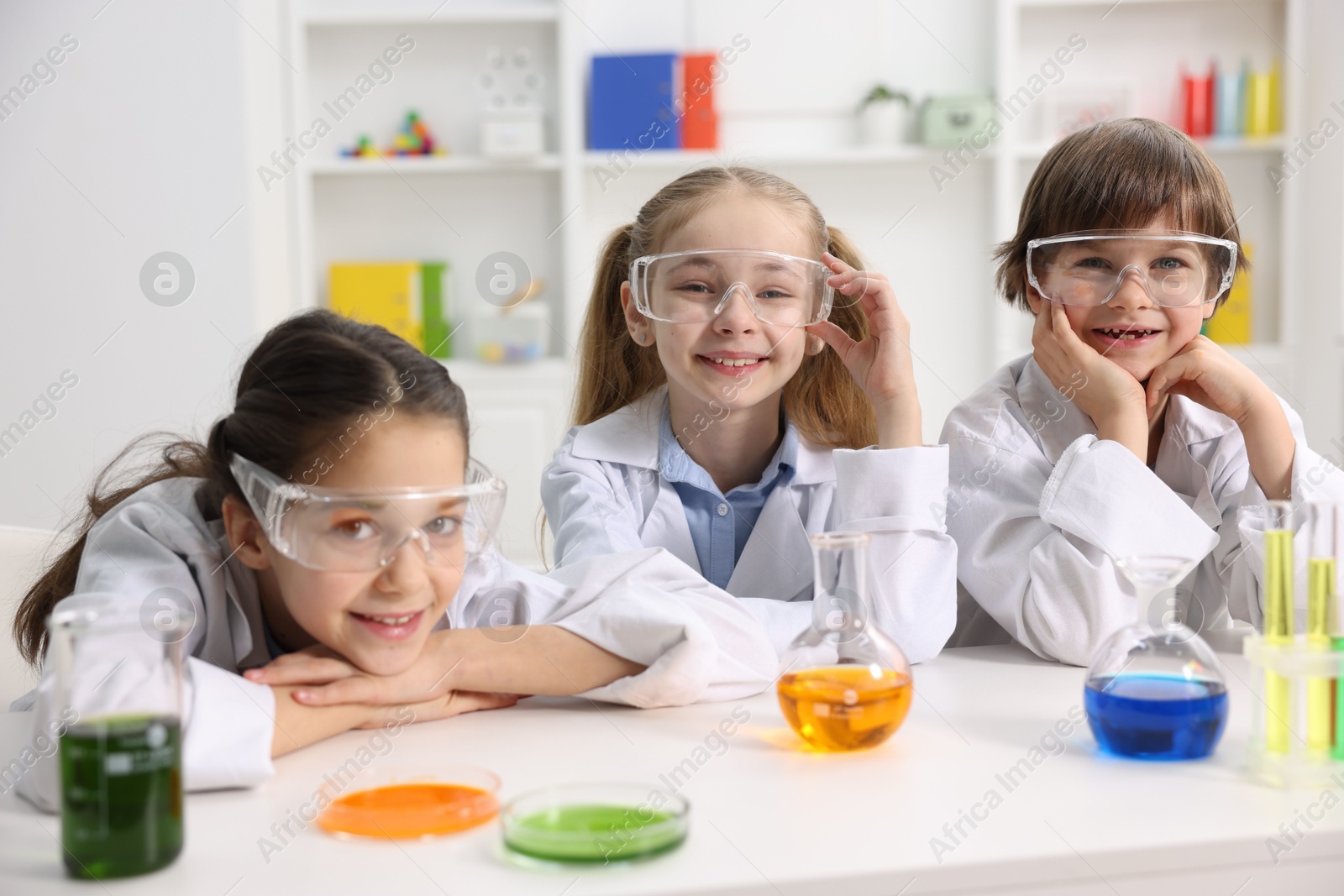 Photo of Children doing chemical experiment at desk indoors