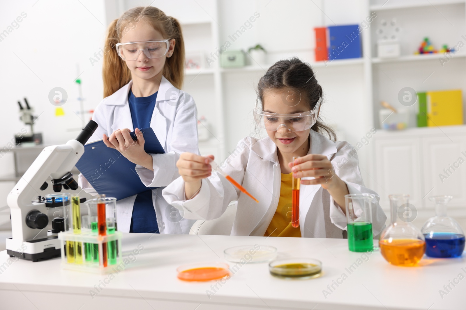 Photo of Children doing chemical experiment at desk indoors