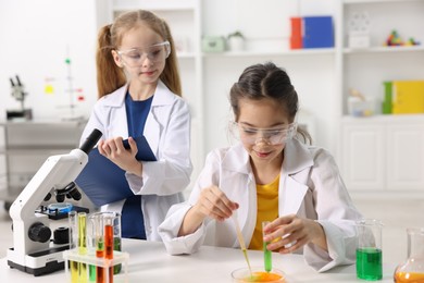 Photo of Children doing chemical experiment at desk indoors