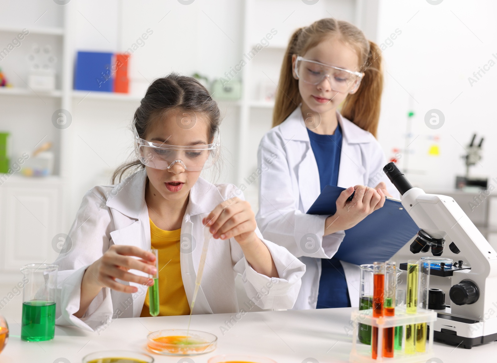 Photo of Children doing chemical experiment at desk indoors