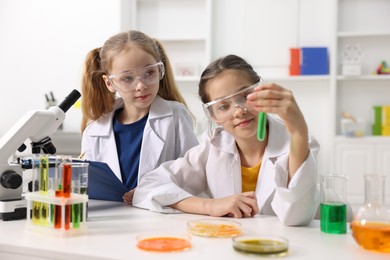 Photo of Children doing chemical experiment at desk indoors