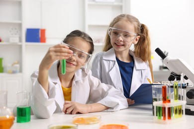 Photo of Children doing chemical experiment at desk indoors