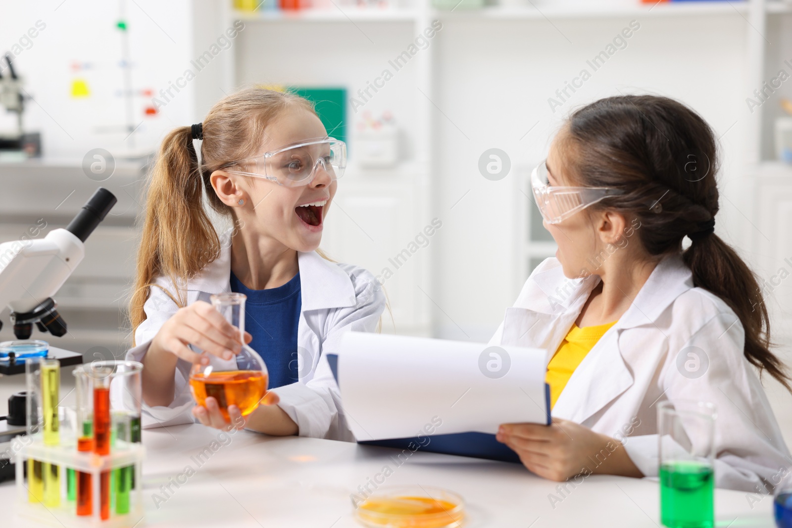 Photo of Children doing chemical experiment at desk indoors