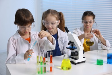 Photo of Children doing chemical experiment at desk indoors