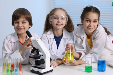 Photo of Children doing chemical experiment at desk indoors