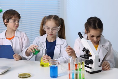 Photo of Children doing chemical experiment at desk indoors