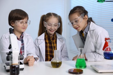 Photo of Children doing chemical experiment at desk indoors