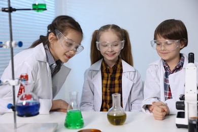 Photo of Children doing chemical experiment at desk indoors