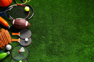 Photo of Different sports equipment on artificial grass, flat lay. Space for text