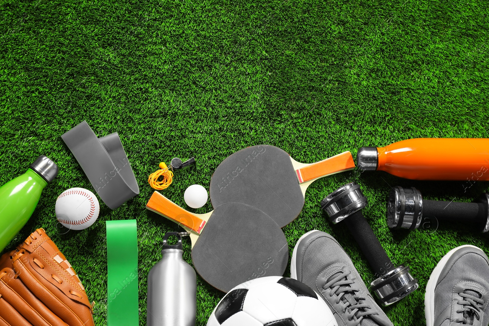 Photo of Different sports equipment on artificial grass, flat lay. Space for text