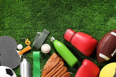 Photo of Different sports equipment on artificial grass, flat lay. Space for text