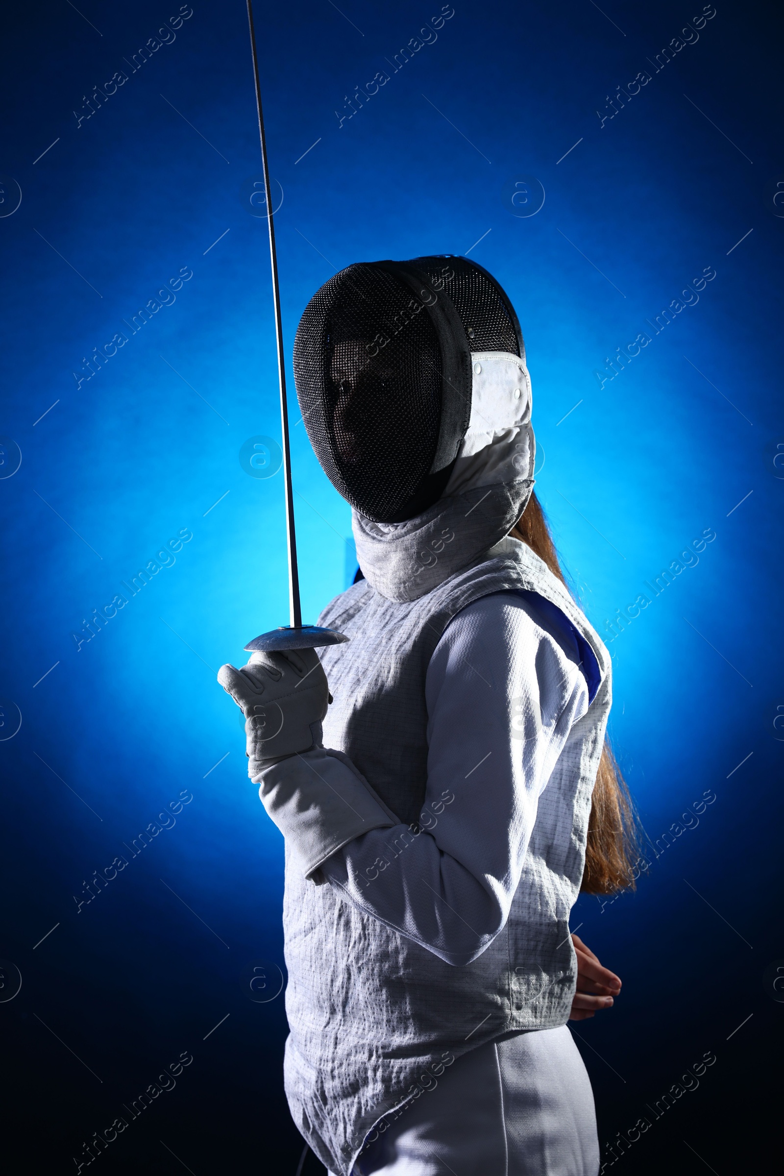 Photo of Fencer with epee on dark blue background