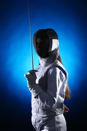 Photo of Fencer with epee on dark blue background