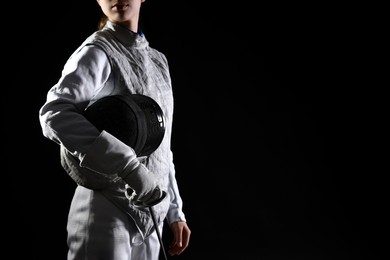 Photo of Fencer with epee on black background, closeup. Space for text