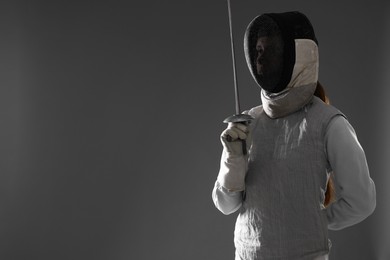 Photo of Fencer with epee on gray background, space for text