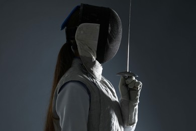 Photo of Fencer with epee on gray background. Combat sport