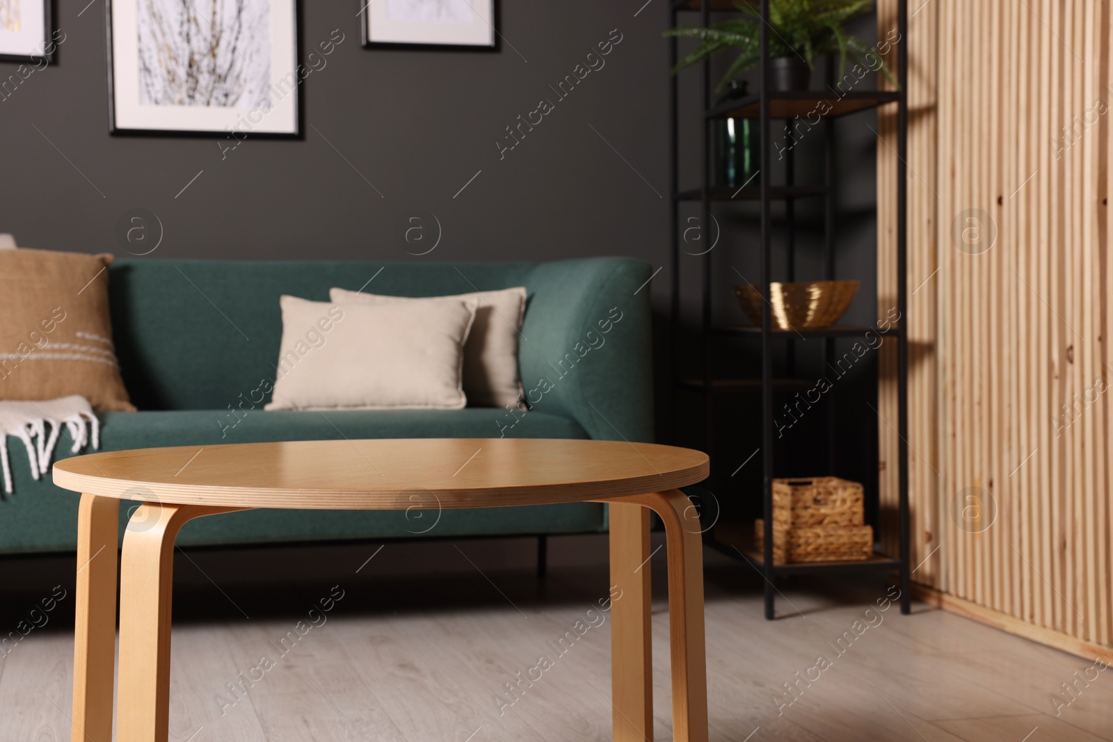 Photo of Wooden coffee table and stylish sofa at home. Interior design