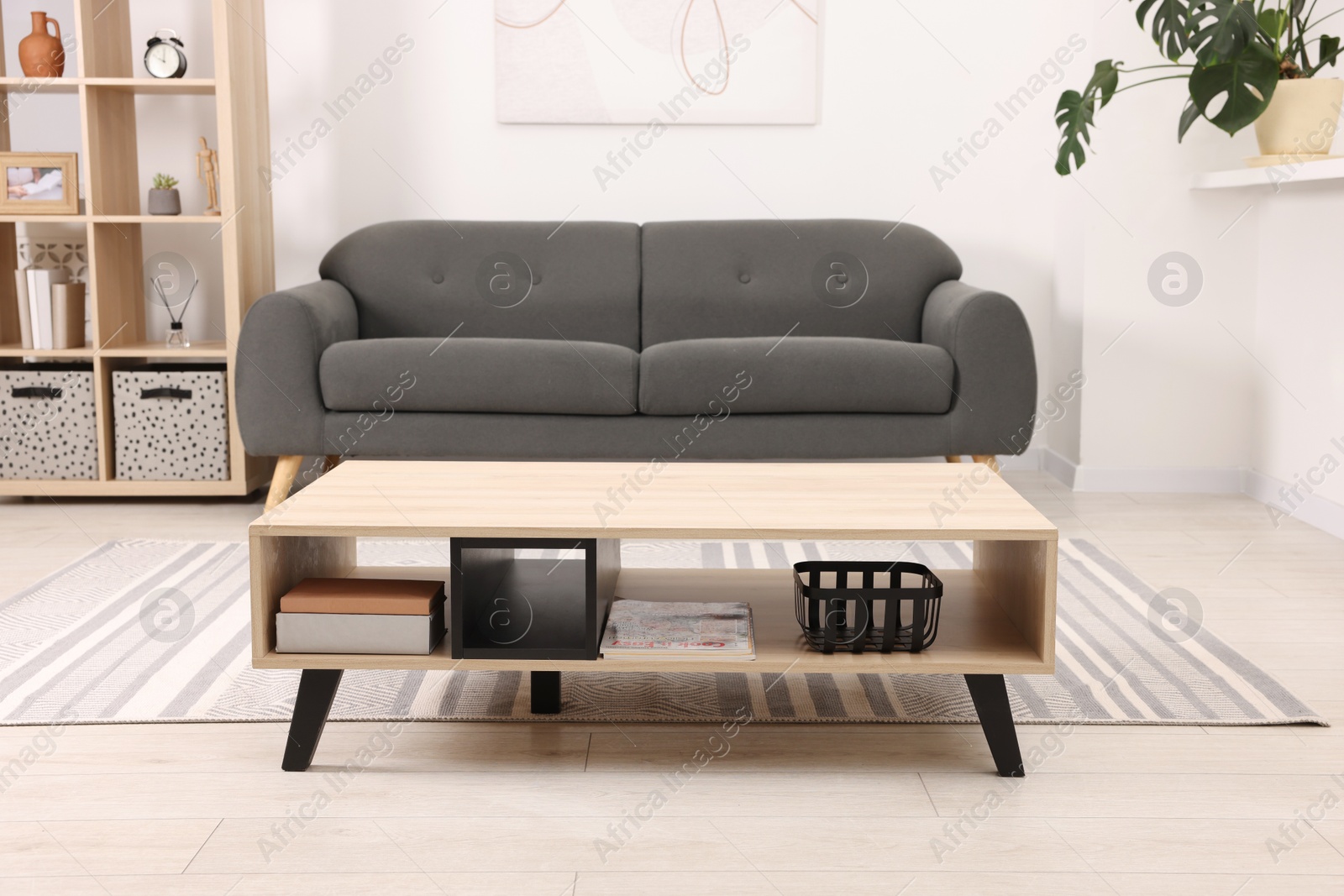 Photo of Stylish coffee table in front of sofa at home. Interior design