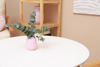 Photo of Stylish coffee table with eucalyptus at home, closeup