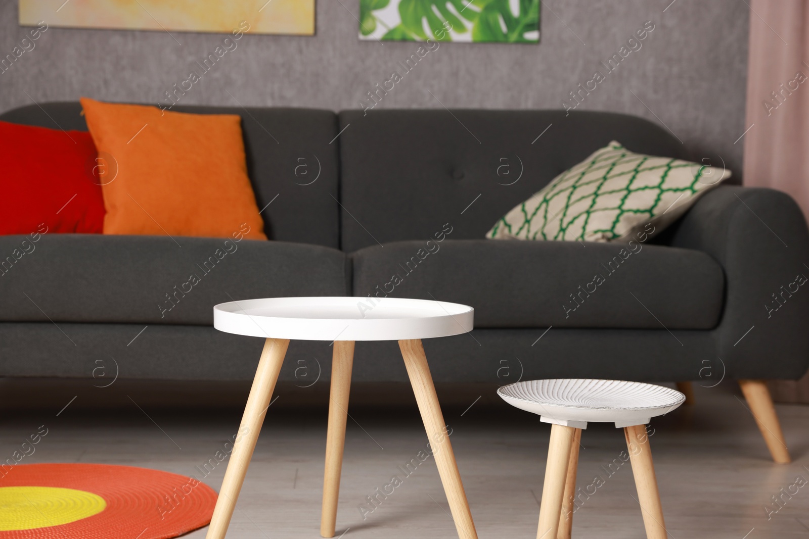 Photo of Stylish nesting tables near sofa at home