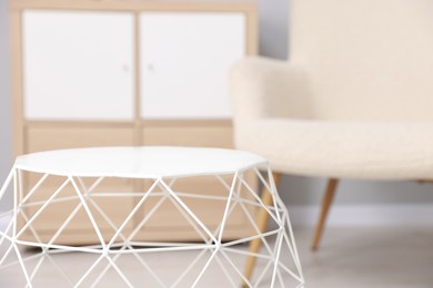 Photo of Stylish coffee table and armchair at home, selective focus