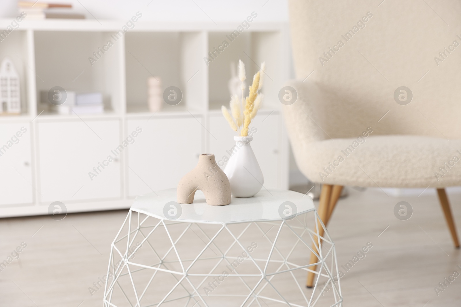 Photo of Stylish coffee table with decor and armchair at home