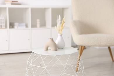 Photo of Stylish coffee table with decor and armchair at home