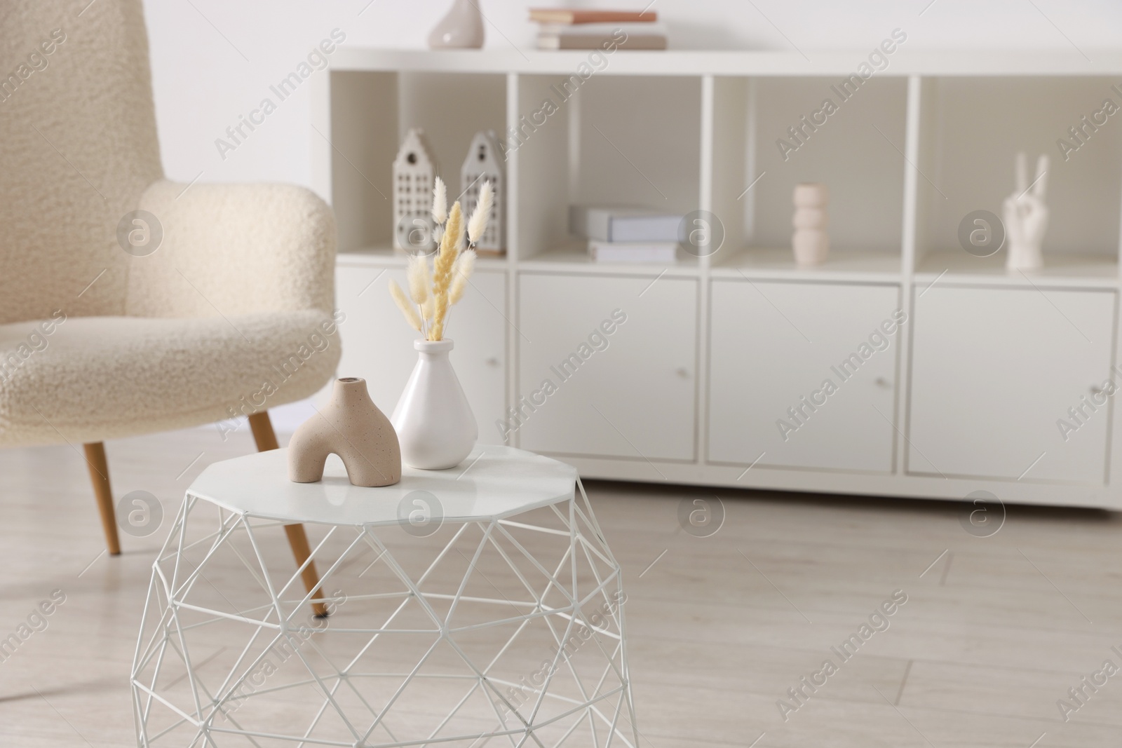 Photo of Stylish coffee table with decor and armchair at home