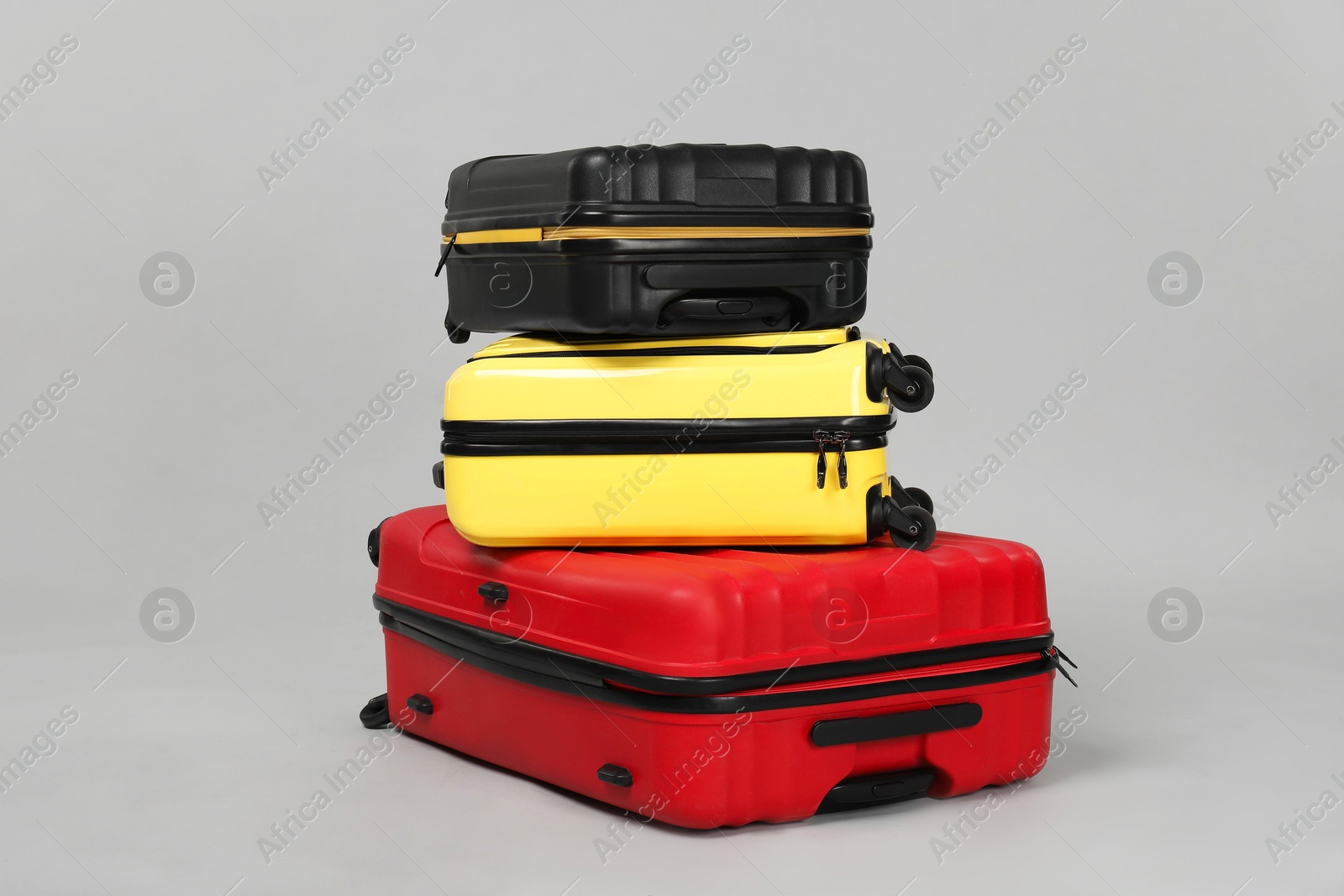 Photo of Stack of colorful suitcases on grey background