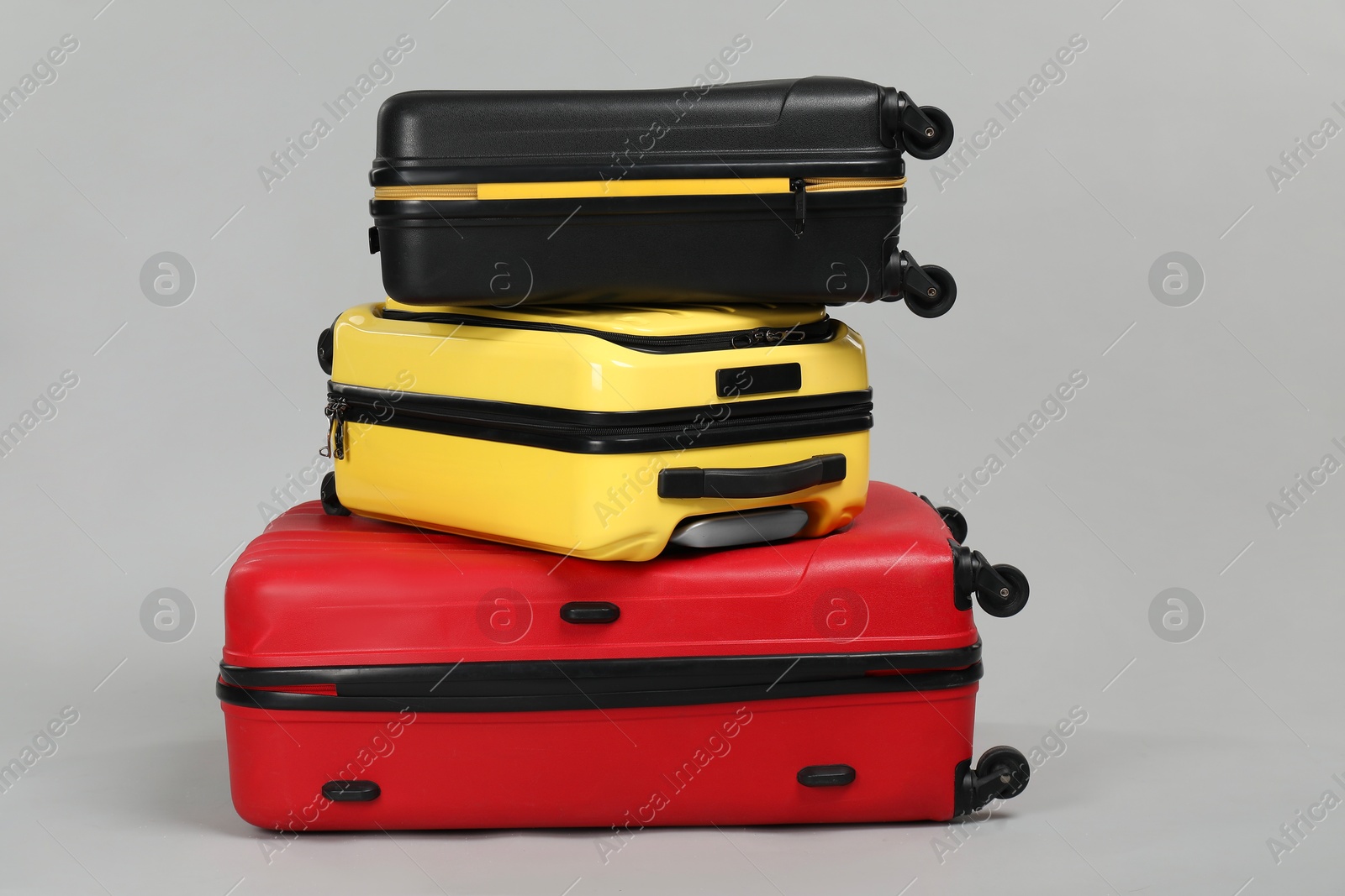 Photo of Stack of colorful suitcases on grey background