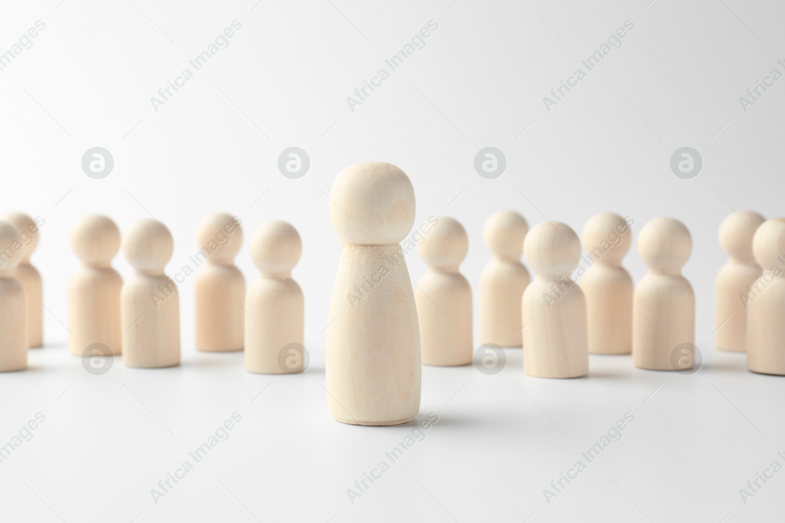 Photo of Big human figure among smaller ones on white background. Competition concept