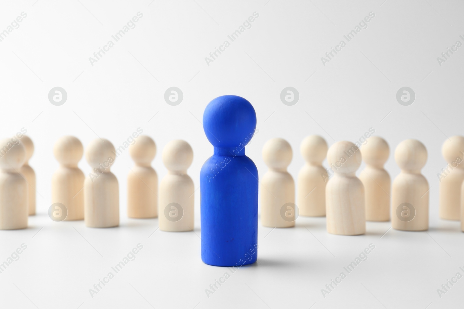 Photo of Blue figure standing out among others on white background. Competition concept