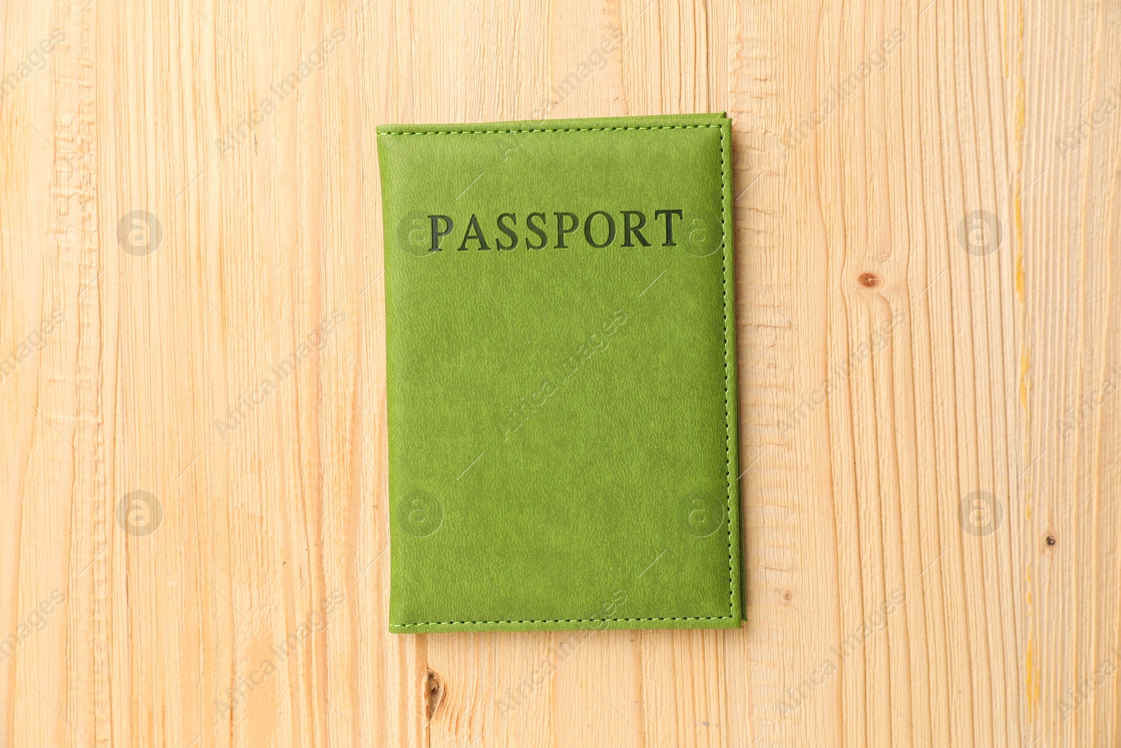 Photo of Passport in green cover on wooden table, top view