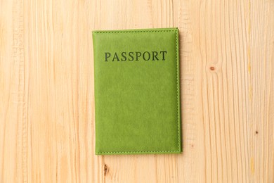 Photo of Passport in green cover on wooden table, top view