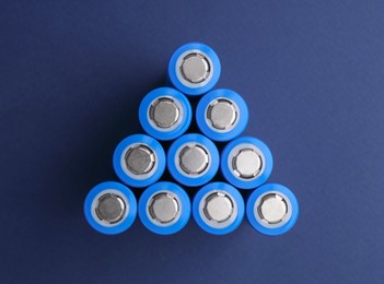 Photo of Many AA cell batteries on blue background, top view