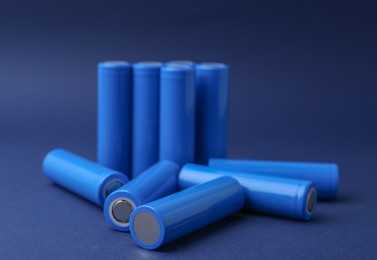 Photo of Many AA cell batteries on blue background, closeup